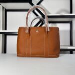 The blue Kelly 25 briefcase and the garden party 36 in Togo brown